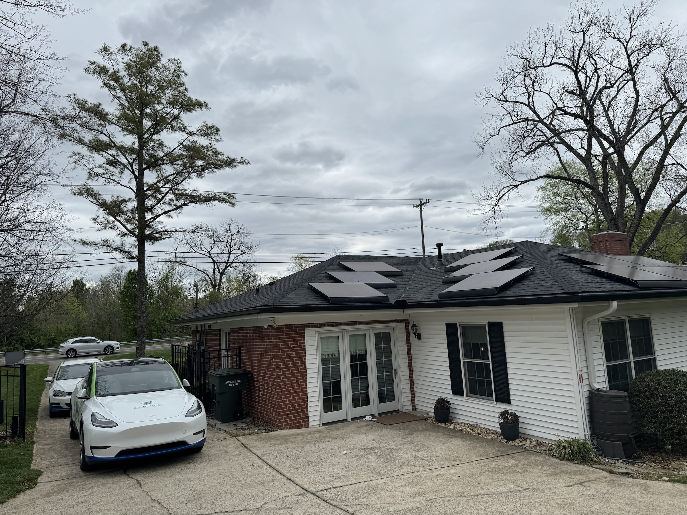 Solar panels on roof of house with Tesla car parked in driveway