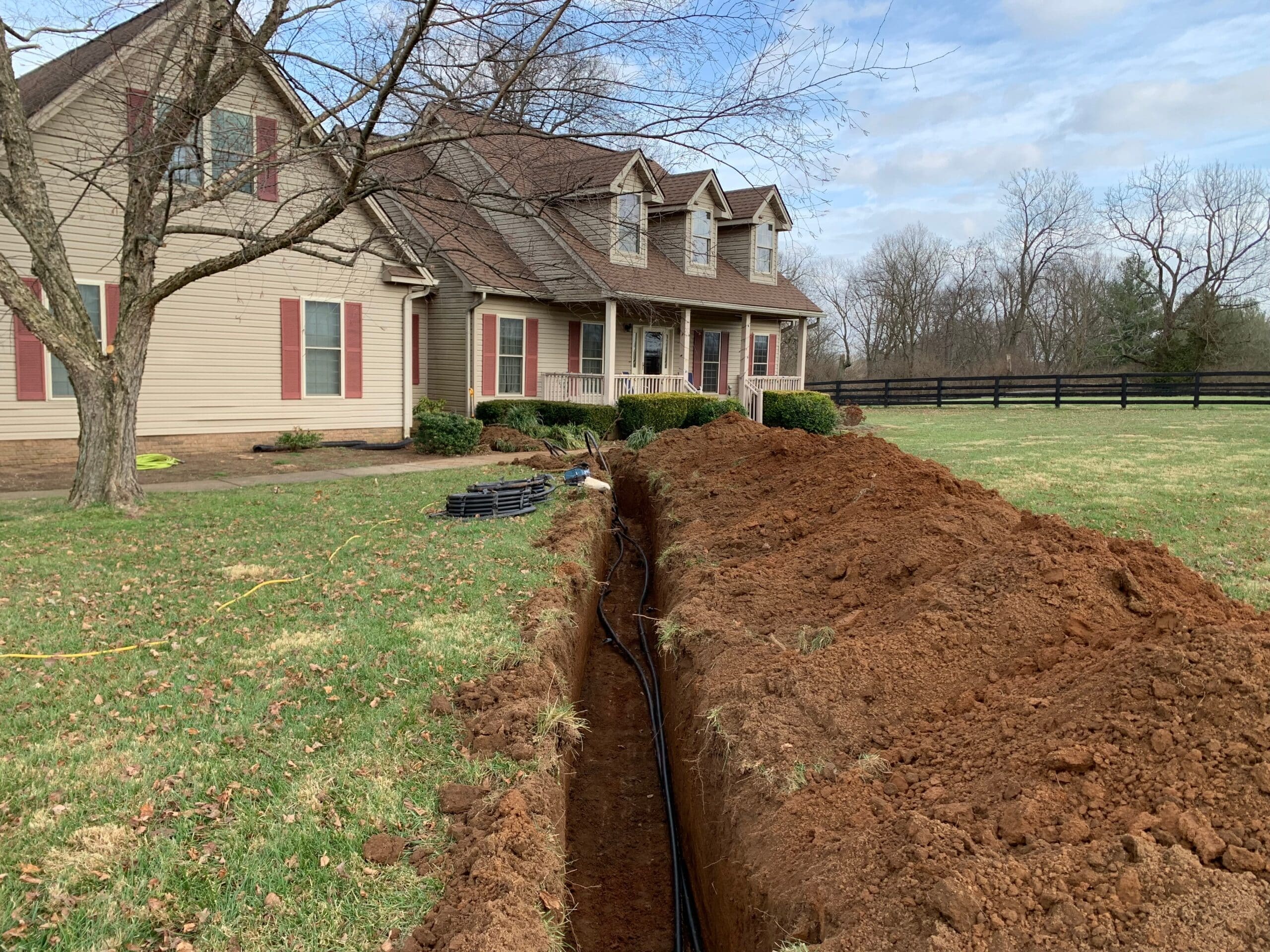 geothermal pipe trench dug outside of a home